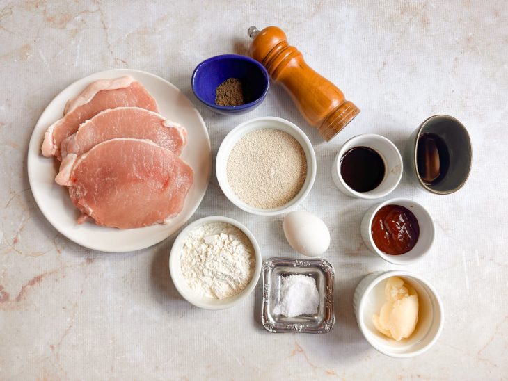 Ingredientes do tonkatsu organizados sobre a bancada.