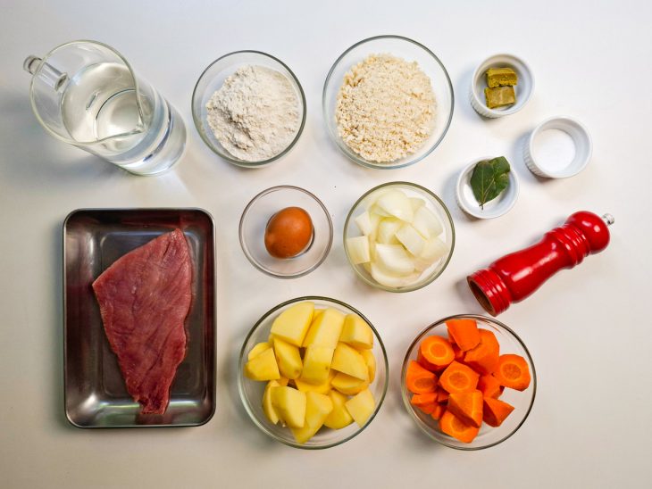 Ingredientes organizados sobre a bancada com legumes já cortados.