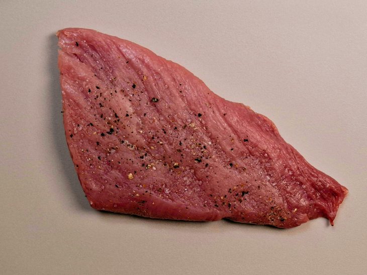 Bife de lombo temperado com sal e pimenta sobre a tábua.