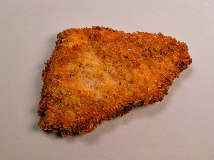 Tonkatsu fritando em óleo quente até dourar.