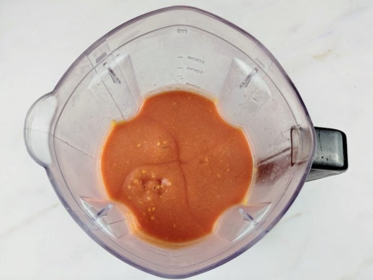 Pedaços de goiaba batidos com água em um liquidificador.