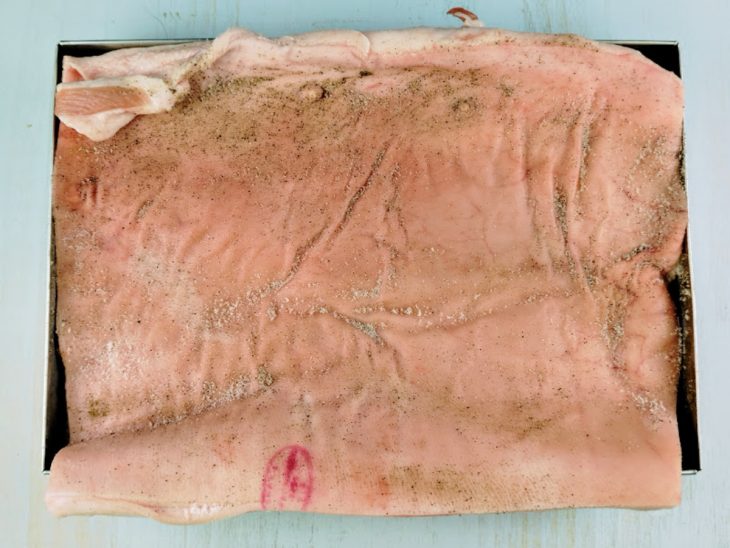 peça de panceta temperada com sal e pimenta do reino.