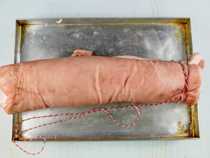peça de panceta enrolada como rocambole com a pele do lado externo.
