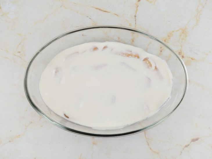 Camada de creme adicionada sobre os biscoitos.