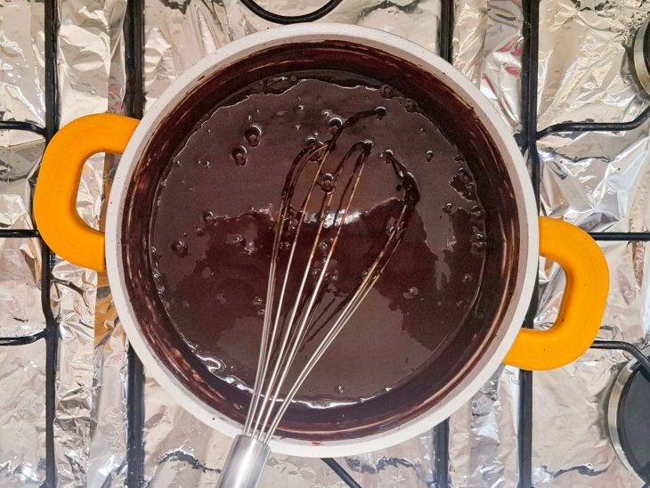 Numa panela, o leite, o chocolate em pó, a manteiga e o açúcar.