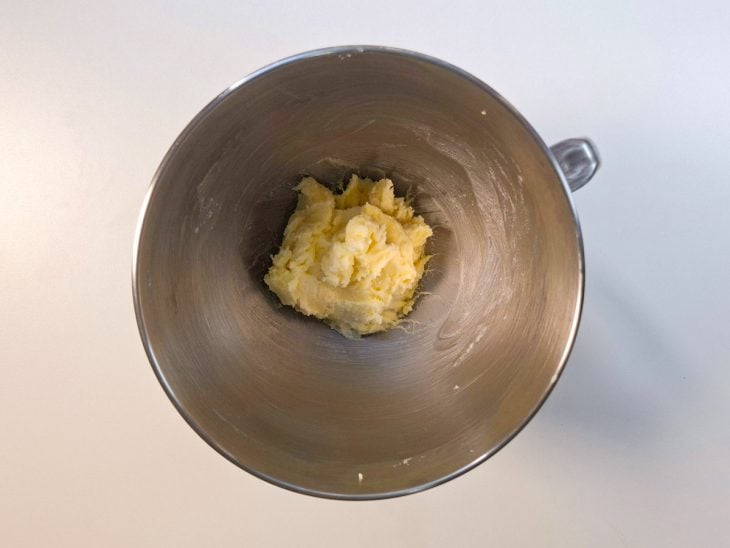 Manteiga e açúcar sendo batidos na batedeira até formar um creme claro e homogêneo.