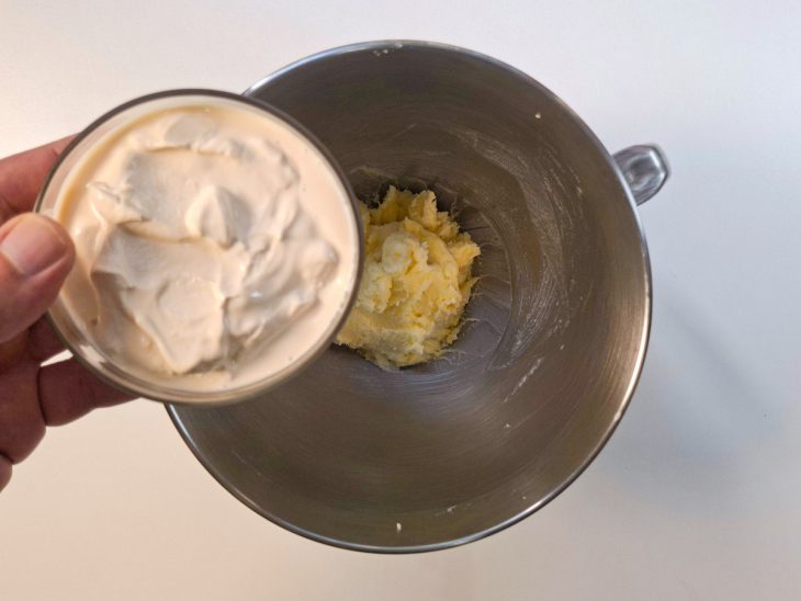 Creme de leite sendo adicionado à mistura e incorporado até ficar liso.