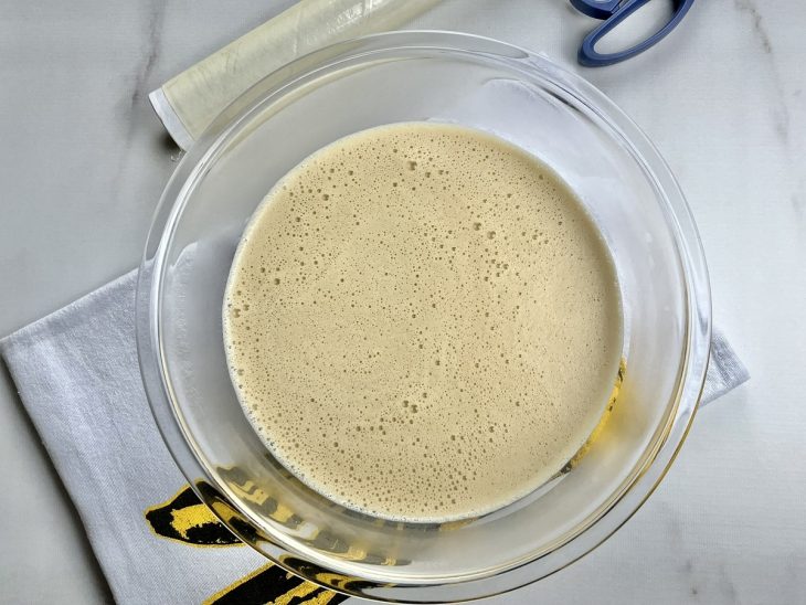 Um recipiente contendo a mistura de caramelo, creme de leite com o soro, leite, eritritol e pectina.