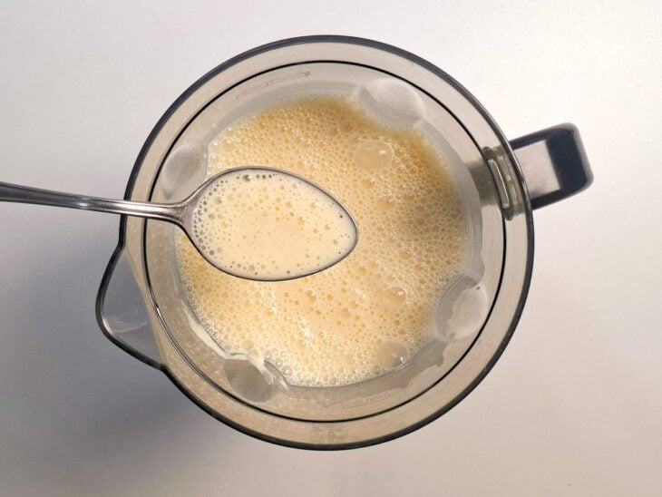 Liquidificador batendo o cream cheese, o creme de leite, o açúcar e a baunilha.