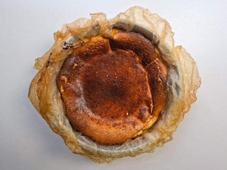 Torta assada exibindo uma superfície bem escura e tostada dentro da forma.