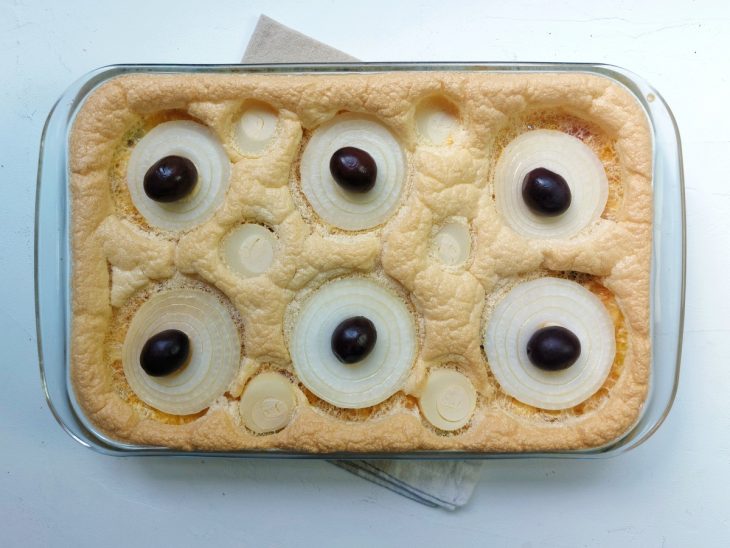 Um refratário contendo torta capixaba de bacalhau.