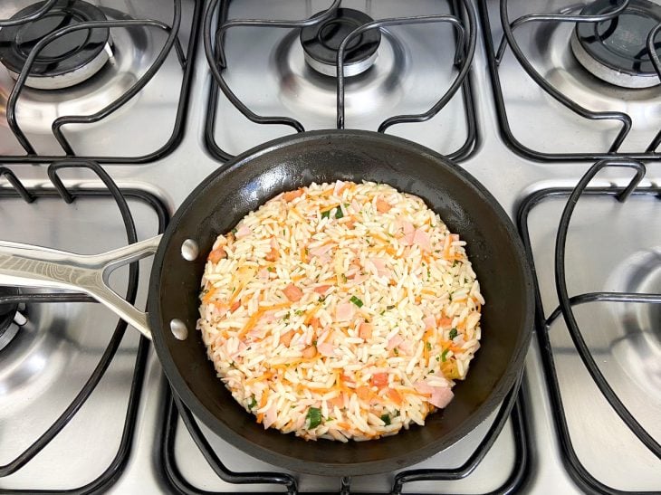 Uma frigideira contendo a mistura de arroz.