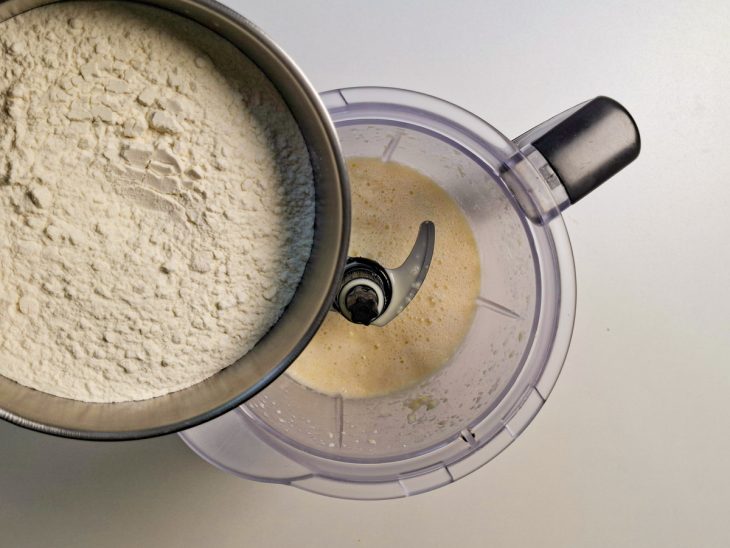 Farinha de trigo e fermento adicionados no processador.