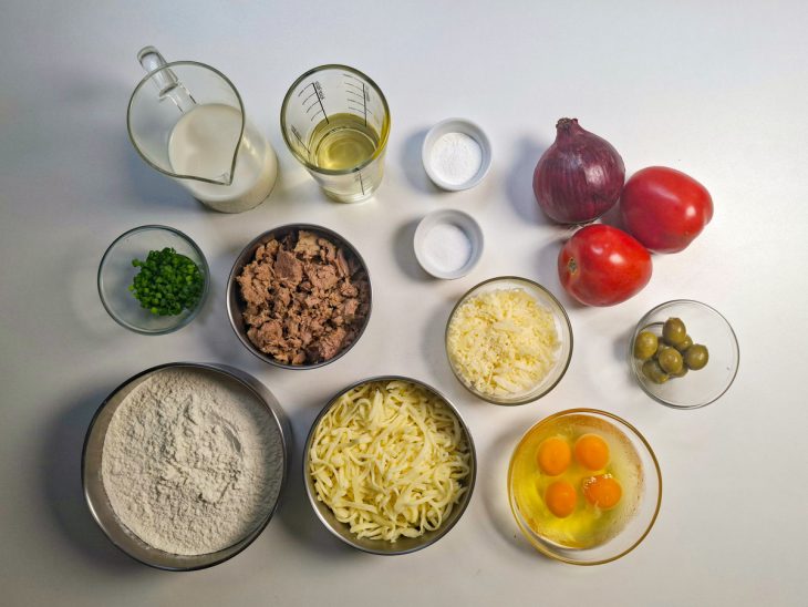 Ingredientes organizados na bancada com ovos já quebrados.