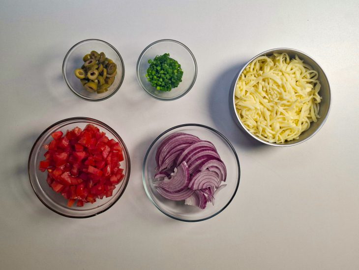 Tomates, cebola, cebolinha e azeitonas picados para o recheio.