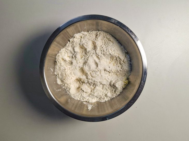 Farinha, sal e parmesão misturados em uma tigela.