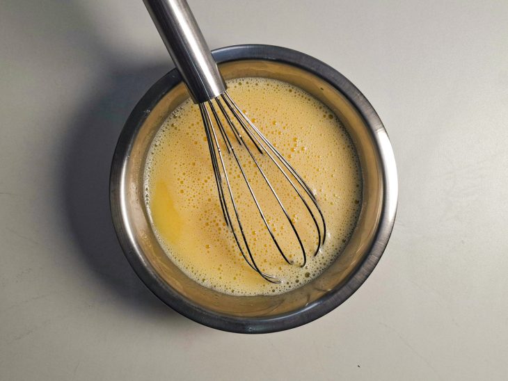 Ovos, óleo e leite sendo batidos com fouet.
