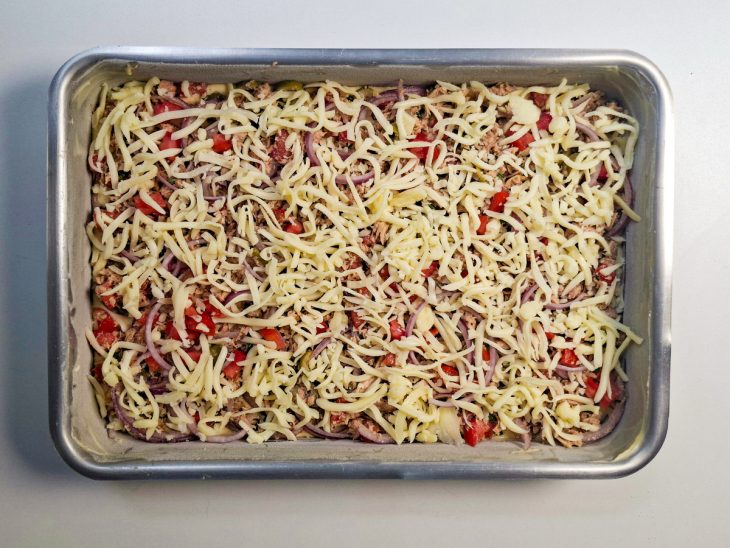 Recheio espalhado sobre a massa crua.