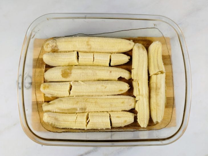Um refratário com o caramelo e uma camada de bananas.