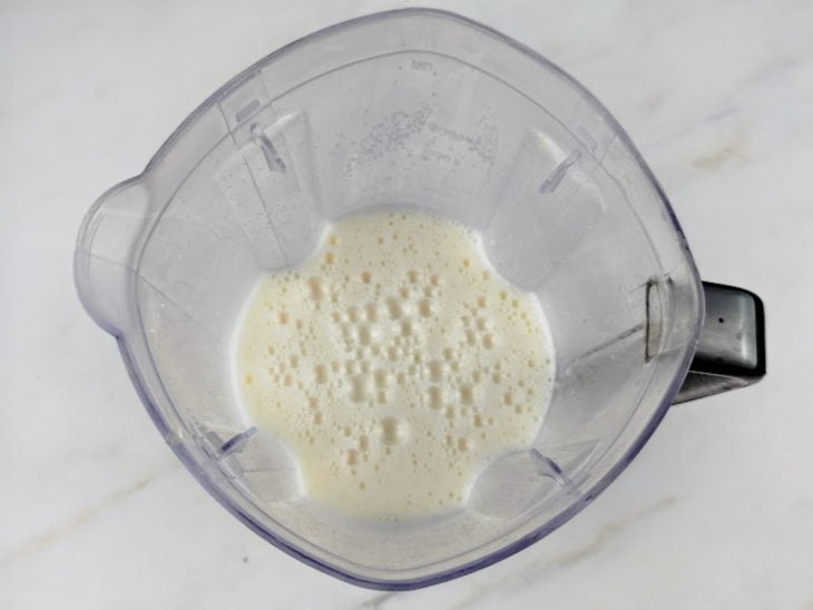 Um liquidificador com leite, ovos e açúcar.