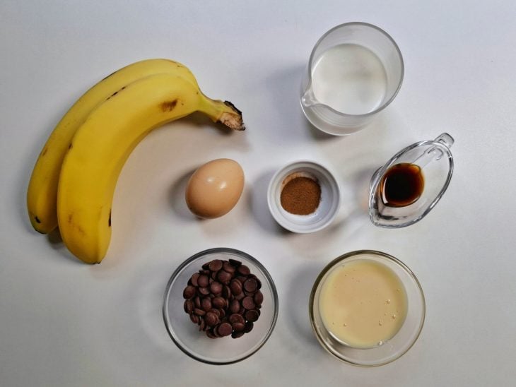 Ingredientes para a receita de torta de banana rápida separados em uma superfície.
