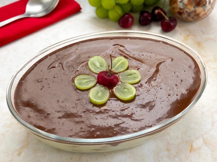 Um refratário contendo torta de bolacha com chocolate fácil.