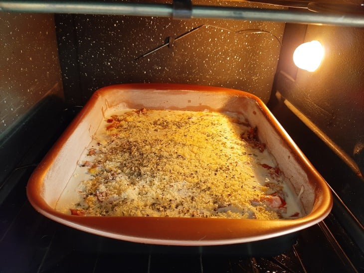 Torta em uma forma de coloração vermelha dentro do forno.