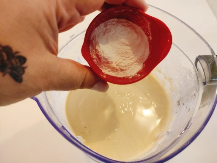 Fermento sendo adicionado ao liquidificador com os outros ingredientes da massa.