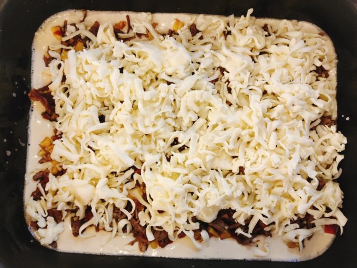 Uma forma com massa, recheio de carne, requeijão e mussarela.