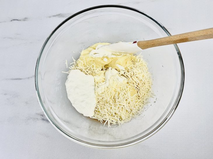 Na tigela, o requeijão, o creme de leite e o parmesão adicionados ao purê.