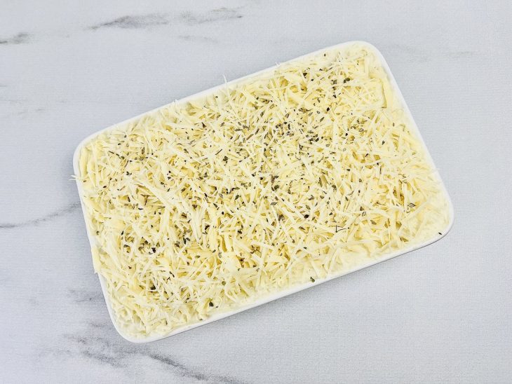 Na travessa, última camada de purê adicionada por cima do refogado, presunto e o queijo.