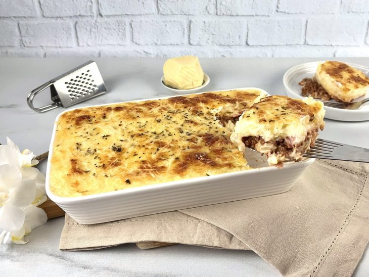 Torta pronta servida em travessa, uma fatia sendo tirada.