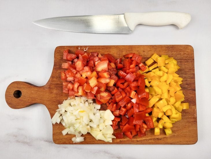 Uma tábua contendo legumes picados.