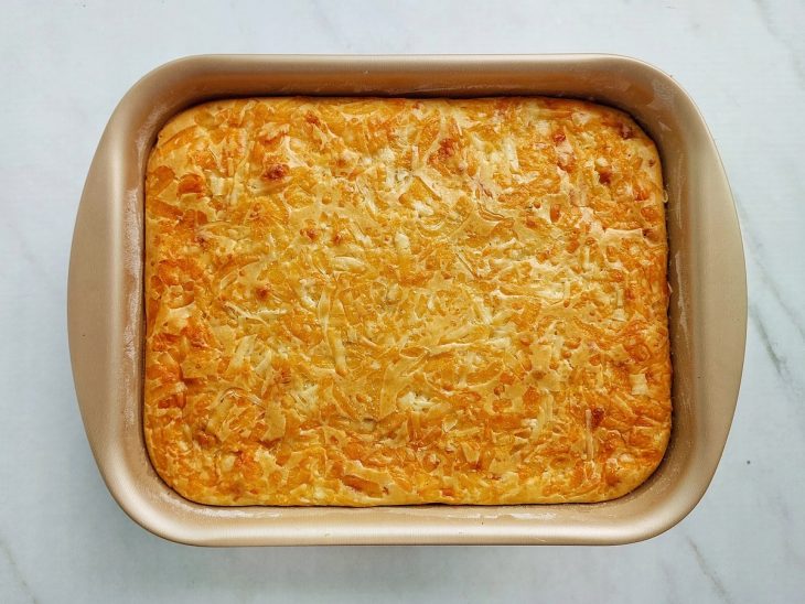 Torta dourada e firme sendo retirada do forno pronta para servir.