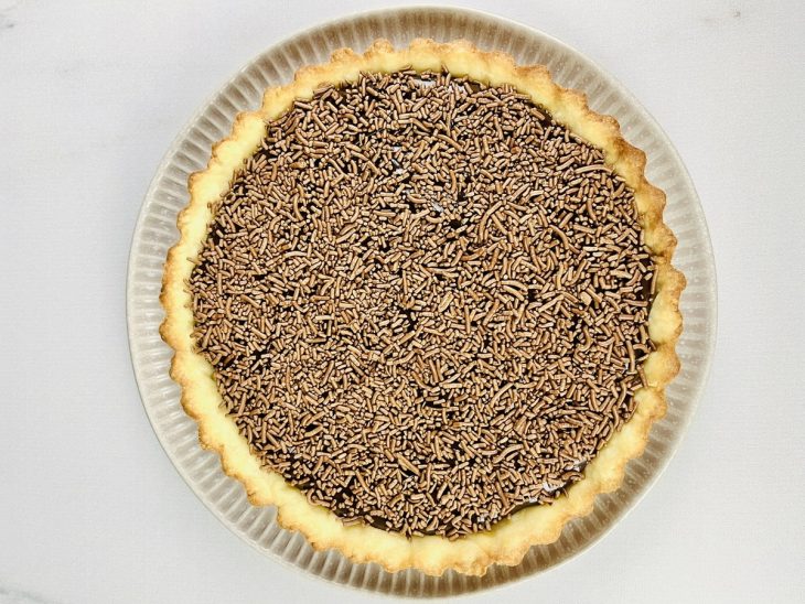Granulado polvilhado sobre a ganache na torta.