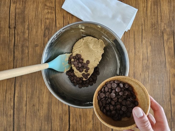 Um recipiente contendo a massa de cookie com gotas de chocolate.