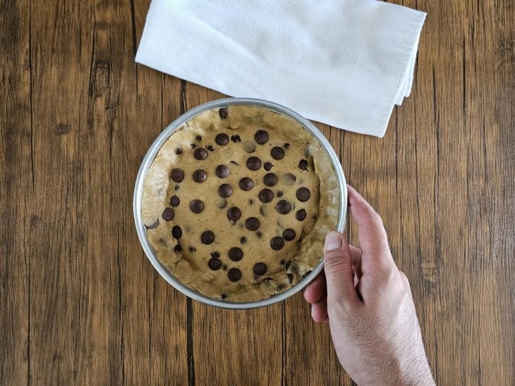 Um recipiente contendo torta crua de cookie com recheio de Nutella.