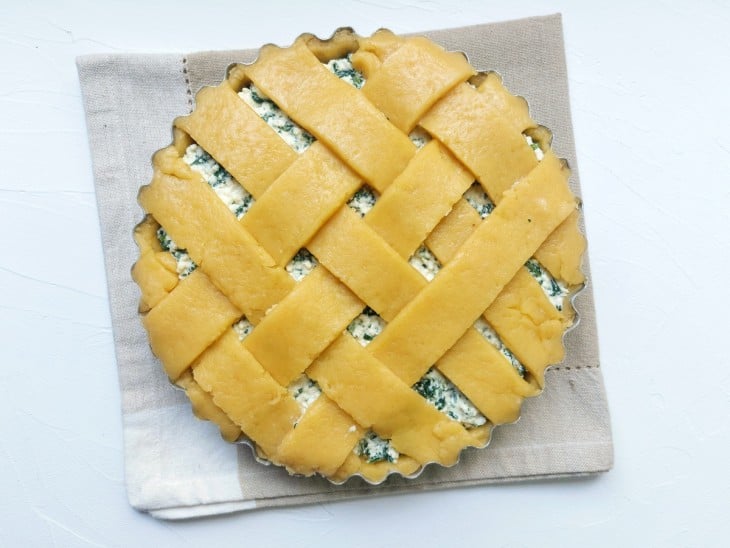 Uma forma contendo torta de espinafre com ricota crua.