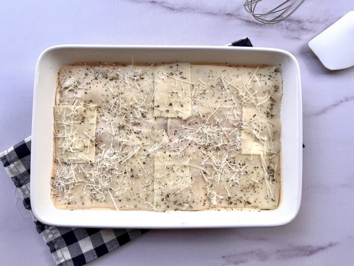 Queijo e orégano colocado em cima da torta.