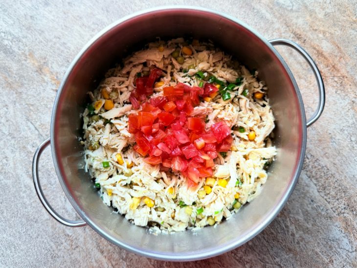 Milho, ervilha, tomate e cheiro-verde adicionados ao frango.