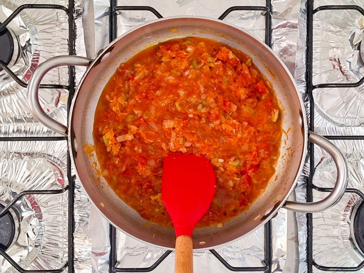 Refogado vermelho com extrato e líquido incorporados formando um molho encorpado.