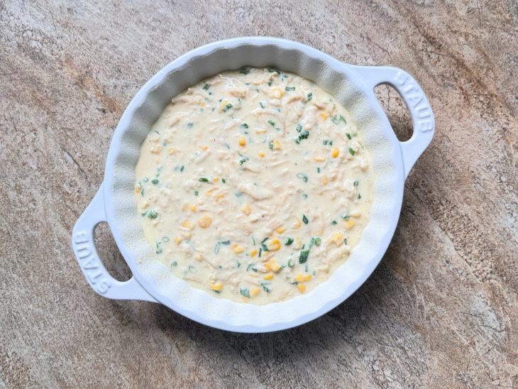 Massa sendo espalhada e nivelada no refratário untado.