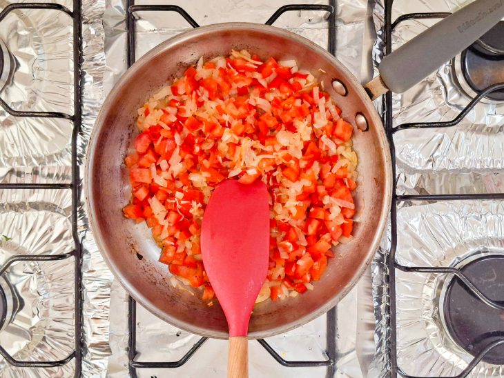 Ingredientes picados sendo refogados na panela.
