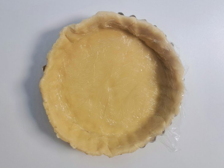 Massa posicionada dentro da forma com fundo removível.