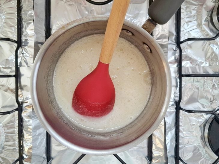 Claras de ovo e açúcar misturados em uma panela.
