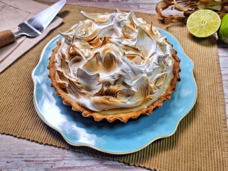 Torta de limão desenformada pronta para consumo e merengue levemente dourado.