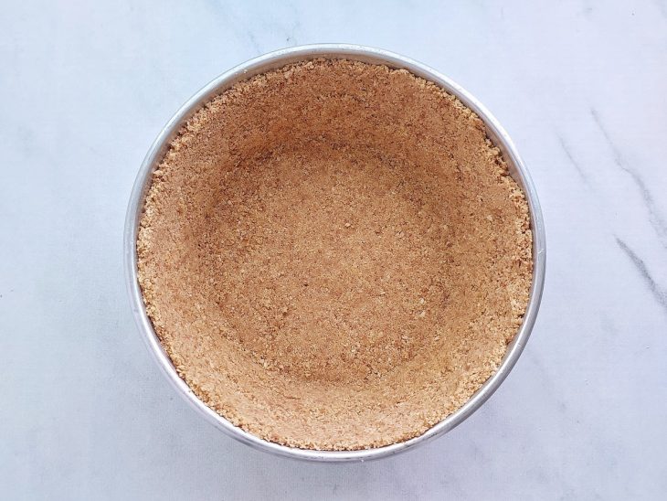 Farofa transferida para a forma e pressionado contra as paredes.