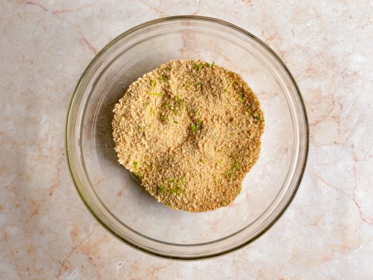Uma tigela com a farofinha de biscoitos e raspas de limão.