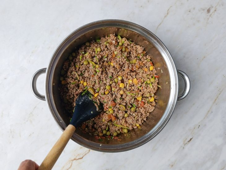 Molho de tomate sendo incorporado ao recheio de carne.