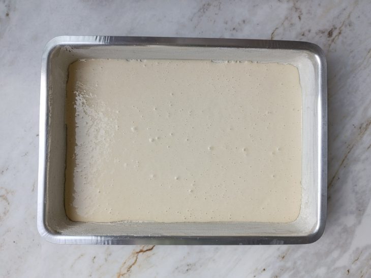 Metade da massa despejada no fundo da forma untada.